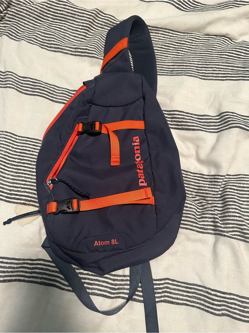 Patagonia navy sling belt bag with orange accents